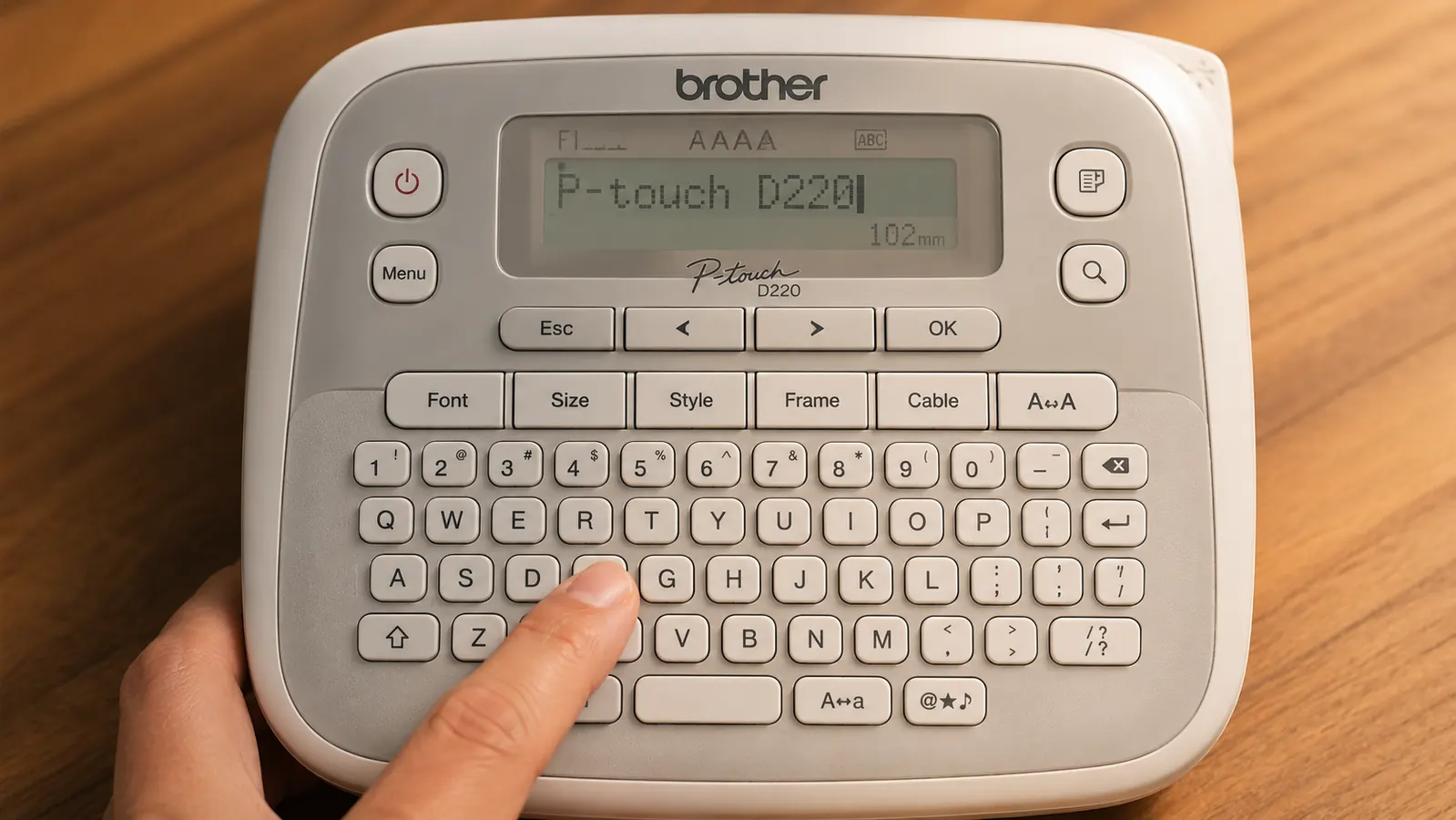 Close-up of a TZe-231 tape cartridge being loaded into the Brother PTD220 label maker